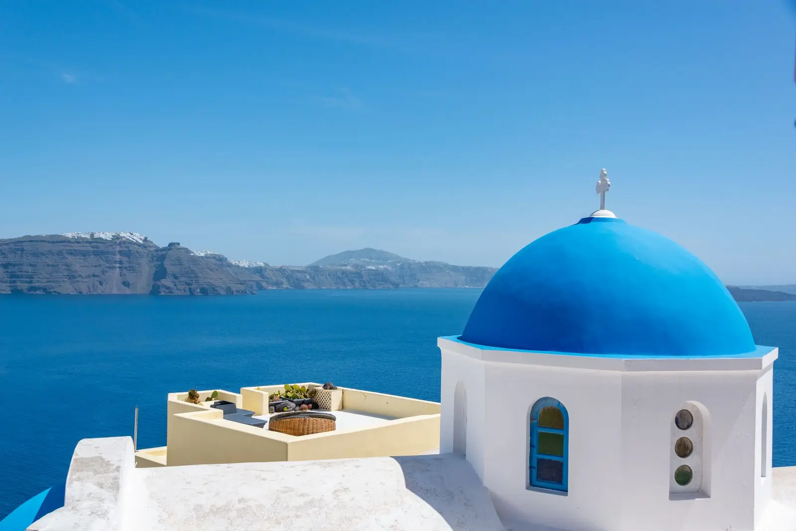 De blauwe koepelkerk van Santorini boven de Egeische Zee